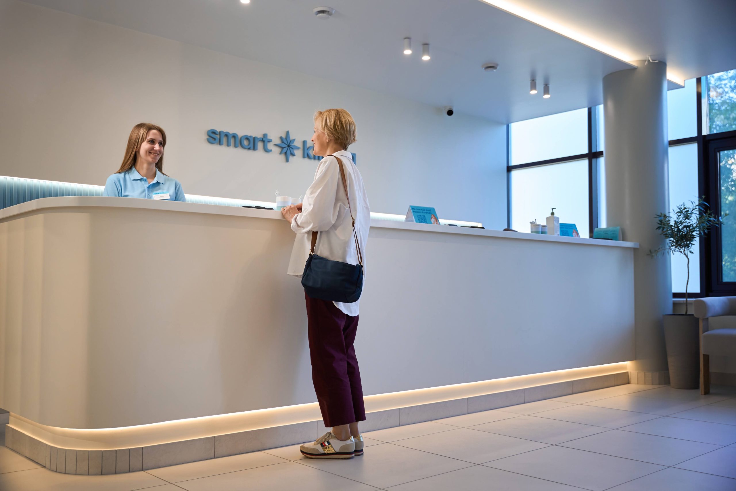 Пацієнт спілкується з адміністратором клініки на рецепції